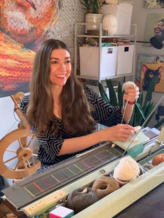 Faith smiling while using her knitting machine
